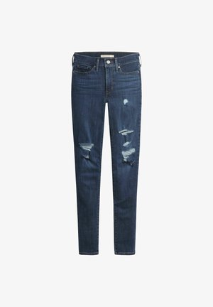 Tmavě modré džíny s úzkým střihem, s opotřebovanými detaily, třásněmi a klasickým pětikapsovým designem.