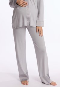 Ensemble de loungewear gris clair comprenant un haut à manches longues avec un ourlet arrondi et un pantalon décontracté assorti avec des accents en satin aux poignets.
