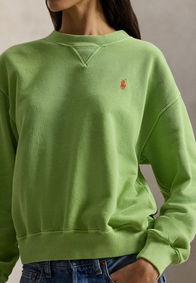 Πράσινο βαμβακερό φούτερ με ριμπ μανσέτες και τελείωμα. Διαθέτει κόκκινο κεντημένο λογότυπο στο στήθος. Κανονική γραμμή, στρογγυλή λαιμόκοψη, απαλή υφή.