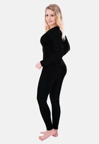 Black athletic outfit featuring a fitted long-sleeve top and leggings. Smooth texture with contrasting seams and logo accents.