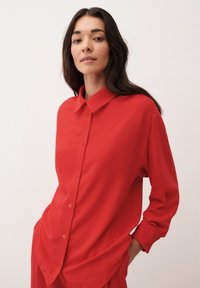 Rode lange mouwen knopen blouse gemaakt van gladde stof, met een kraag en vooraan knopen, met een ontspannen pasvorm en opgerolde manchet.