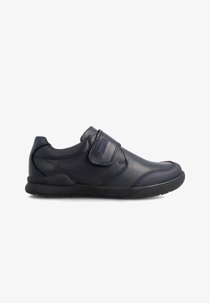 Zapatos negros de cuero sin cordones que presentan una correa de velcro, punta redondeada y detalles texturizados en la parte superior. Suela de goma para agarre y comodidad.