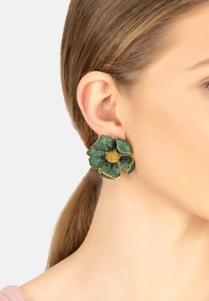 Green flower-shaped earrings made of textured material, featuring yellow accents and a gold outline, designed to attach to the ear.