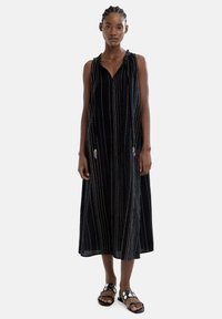 Czarna sukienka bez rękawów z pionowymi kolorowymi paskami, z dekoltem w kształcie litery V i bocznymi zdobieniami. Urokliwy krój A-line z teksturowanym wykończeniem.