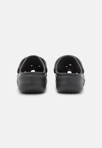Schwarze Gummi-Clogs mit offenen Fersen, Belüftungsöffnungen, strukturierten Sohlen und dem eingeprägten "CROCS"-Logo an der Ferse. Leichtes Design.