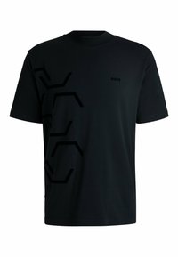 T-shirt noir à manches courtes en tissu lisse avec un motif géométrique texturé sur le côté gauche et un petit logo de la marque sur la poitrine.