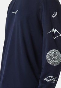 Marineblaues langärmliges Sportshirt aus strukturiertem Stoff. Mit weißem ASICS-Logo, Berggrafiken und Schriftzügen auf den Ärmeln.