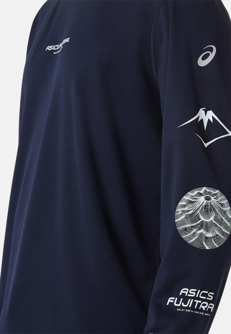 T-shirt de sport à manches longues bleu marine en tissu texturé. Présente le logo ASICS blanc, des motifs de montagne et du texte sur les manches.
