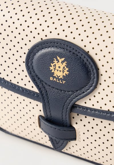 Κρεμ τσάντα από διάτρητο δέρμα με επένδυση από σκουρόχρωμο μπλε δέρμα και λογότυπο της Bally σφραγισμένο με χρυσό στο κούμπωμα.