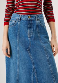 Blauwe denim rok met een voorkeursplit, vijf-pocket ontwerp en gouden hardware op de tailleband. Glad textuur en medium-lichte wassing.