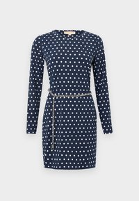 Μακρυμάνικο φόρεμα σε ναυτικό μπλε με λευκές πουά και ασημένια αλυσίδα-ζώνη που κρέμεται γύρω από τη μέση.