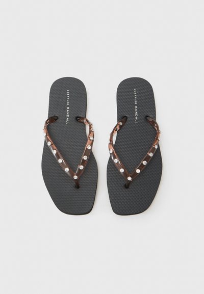 Svart gummitøffel med en teksturert såle, med en brun gjennomsiktig stropp prydet med klare rhinestones i en V-formet design.