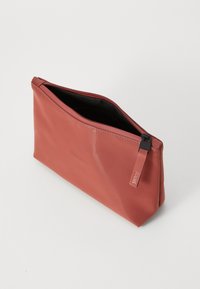 Pochette con zip color corallo realizzata in materiale impermeabile, caratterizzata da una texture liscia e un interno nero, con un dettaglio logo discreto.