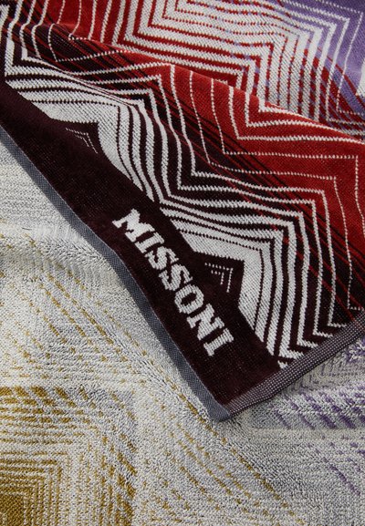 Mitmevärviline rannarätik, millel on punase, valge ja lilla tooni zig-zag mustrid, pehme tekstuuriga ning valge Missoni logo ääres.