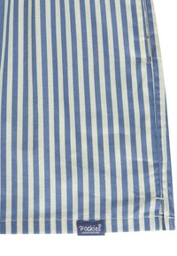 Tissu rayé en bleu clair et crème, avec des rayures verticales, texture lisse, et une étiquette avec "Pockies Couch Couture" au bord.