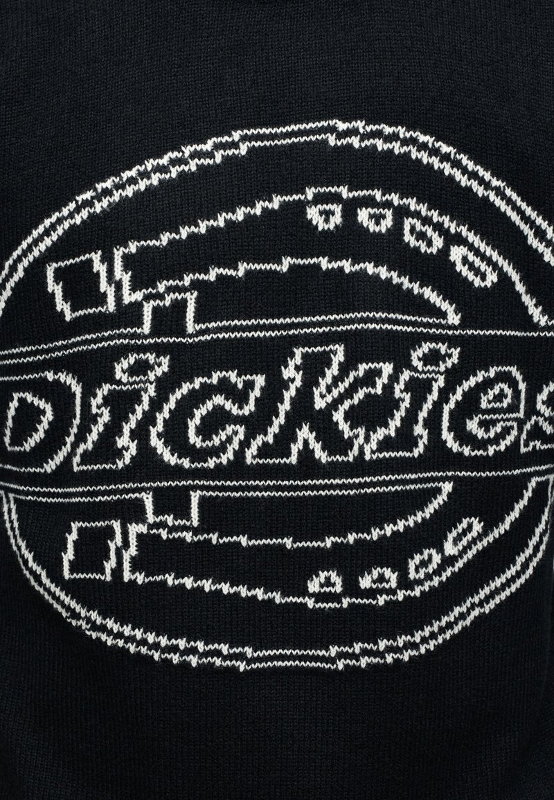 Schwarzer Strickstoff mit einem weißen, gestickten, runden Logo, das das Wort "Dickies" in stilisiertem Text zeigt.