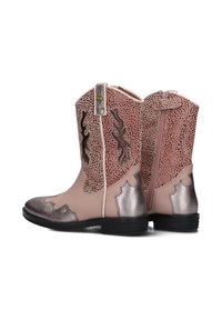 Rosa Cowboystiefel mit perforierten Seiten, metallischen Akzenten und aufwendigen Lederdetails; seitlicher Reißverschluss und niedriger schwarzer Absatz.