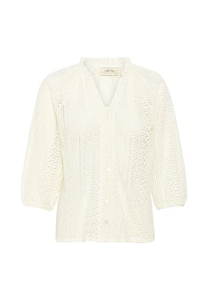 Blouse blanche avec un motif de dentelle texturée, des manches bouffantes trois-quarts, une fermeture à boutons à l'avant et un col haut avec un bord volanté.
