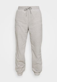Hellgraue Sweatpants aus weichem Material, mit einem elastischen Bund und Kordelzug sowie Bündchen an den Knöcheln für eine entspannte Passform.