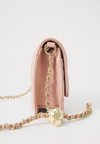 Rosa läderväska med en guldkedjeslinga, med en dekorativ detalj i guld vid änden och en texturerad yta.