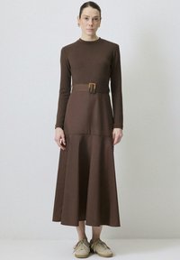 Robe à manches longues, en tissu doux, de couleur marron, avec un corsage ajusté et une jupe évasée, dotée d'une ceinture assortie avec une boucle rectangulaire.