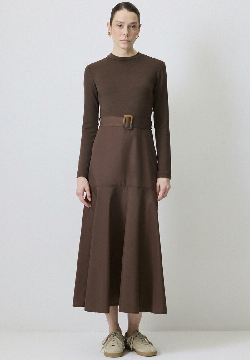 Robe à manches longues, en tissu doux, de couleur marron, avec un corsage ajusté et une jupe évasée, dotée d'une ceinture assortie avec une boucle rectangulaire.