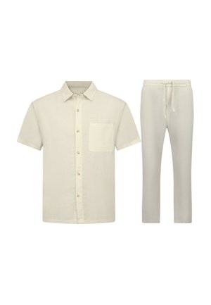 Beige kortärmlig overhemd met borstzak en bijpassende beige broek met trekkoord op witte achtergrond.