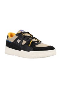 Svarta och beige sneakers med mockadetaljer, perforerade paneler och gul foder. Har svarta snörningar och en vit gummisula.