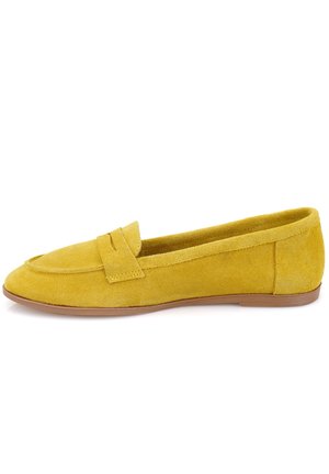Mocassin femme en daim jaune avec une semelle plate marron et une bride décorative sur le dessus, vu de côté.