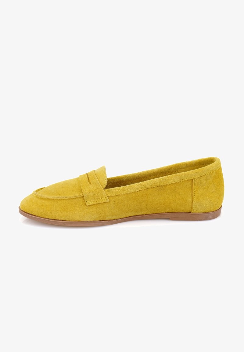 Mocassin femme en daim jaune avec une semelle plate marron et une bride décorative sur le dessus, vu de côté.