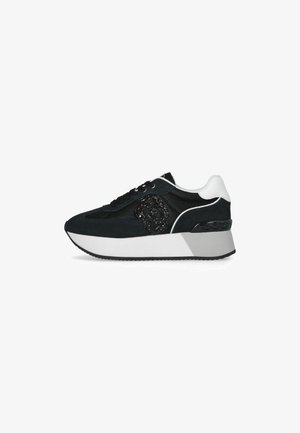 Sneaker nera realizzata in materiali mesh e suede, con un design testurizzato nero, dettagli bianchi e una suola chunky con un tallone decorato.