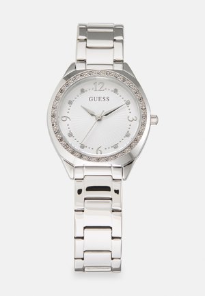 Montre-bracelet en métal argenté avec un cadran blanc à motif, une lunette étincelante et des marqueurs en cristal. Elle dispose d'un bracelet en maillons poli.