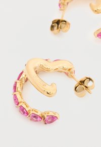 Χρυσά σκουλαρίκια κρίκοι με ροζ πέτρες σε σχήμα σταγόνας, τοποθετημένες σε καμπύλο, υφασμένο σχέδιο, με κουμπώματα τύπου push-back για ασφαλή στήριξη.