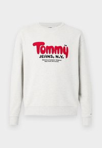 Light gray crewneck sweatshirt with red "Tommy" and black "Jeans, N.Y." text on the front, plus smaller black text below.