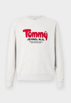 Sudadera de color gris claro con cuello redondo, con el texto rojo "Tommy" y el texto negro "Jeans, N.Y." en la parte frontal, además de un texto negro más pequeño debajo.