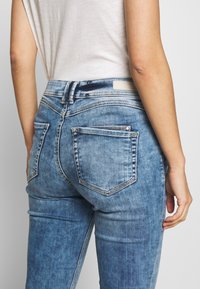 Bleka blå denimjeans med midjehöjd, fem fickor och klassisk passform. Har en mjuk textur och logotags vid midjebandet.