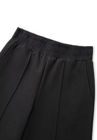 Zwarte broek met een geribbelde elastische tailleband, met een relaxte pasvorm en voorplooien, gemaakt van zachte stof. Inclusief zijzakken.
