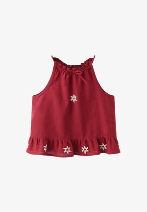 Haut rouge sans manches avec encolure et ourlet à volants, décoré de petits motifs d’étoiles blanches brodées.