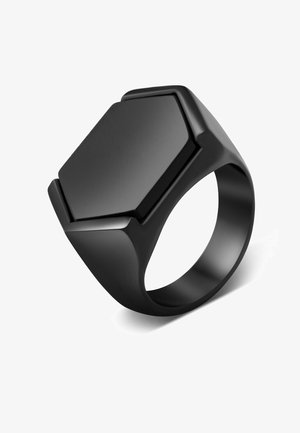 Anillo negro con una parte superior plana hexagonal, superficie lisa y bordes redondeados, elaborado con un material sólido para mayor durabilidad.