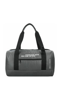 Bolsa de deporte gris con correas negras, que cuenta con un bolsillo con cremallera y una marca blanca. Fabricada con un tejido duradero y de textura suave.