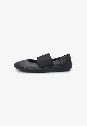 Black leather flat shoe with elastic strap across the instep, rounded toe, and textured rubber sole for grip. Minimalist design.