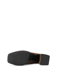 Scarpa in suede marrone con punta quadrata, suola in gomma nera e superficie texturizzata per una presa migliore. Il tacco è basso e leggermente arrotondato per maggiore stabilità.