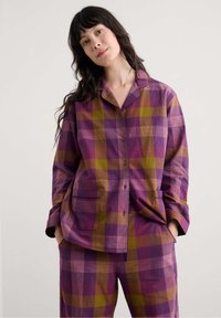 Multikleurige geruite set in paars, bruin en groen. Knopsluitende shirt met zakken, losse pasvorm. Bijpassende broek met een soortgelijk patroon.