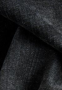 Schwarzer Denim-Stoff mit weicher Textur und leichtem Stretch. Verfügt über eine enge Webart und subtile Farbvariationen auf der Oberfläche.