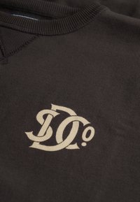 Felpa marrone con un prominente logo beige "D0", scollo a costine e tessuto dalla texture liscia.