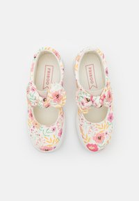 Canvas schoenen met bloemenpatroon, afgeronde neus, geknoopte strik-accent en elastische band. Dominante kleuren zijn roze, geel en groen.