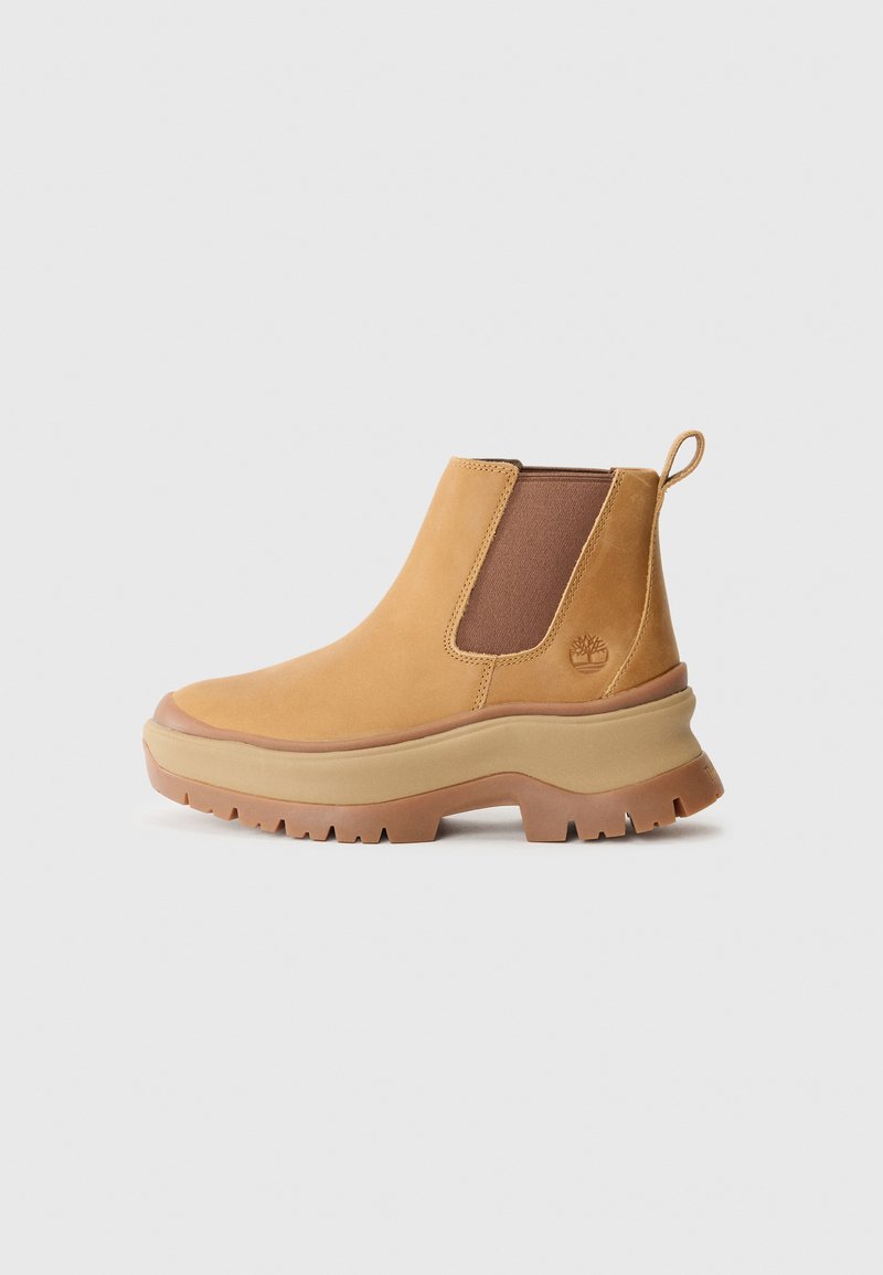 Tan leather ankle boot with elastic side panels, rounded toe, and thick rubber sole with deep tread; features a pull tab at the heel.