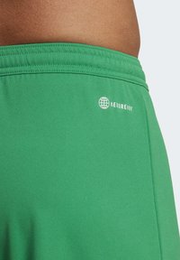 Groene sportshorts van gladde stof. Voorzien van een elastische tailleband en een klein wit 'AEROREADY' logo aan de zijkant.