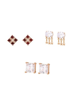 Trzy pary złotych kolczyków: czerwono-białe kolczyki w kształcie kwadratu, owalne z przezroczystym kamieniem i wiszącymi złotymi gwiazdkami oraz przezroczyste kwadratowe kolczyki z łapkami.