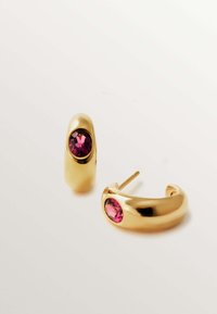 Pendientes de aro de oro con una prominente gema rosa. Superficie lisa y brillante, con bordes redondeados; un par incluye un pasador para sujetar.